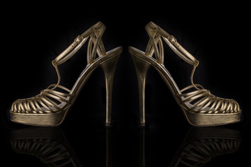 A Pair of Gold Leather High Heels Sandals on Black  Background