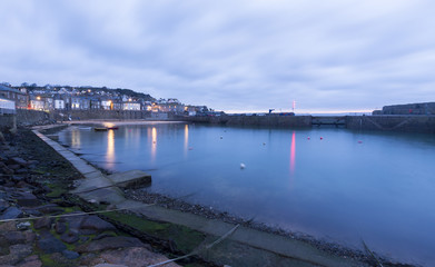 Mousehole Harbour in Cornwall at sunrise.
