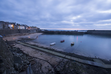 Mousehole Harbour in Cornwall at sunrise.