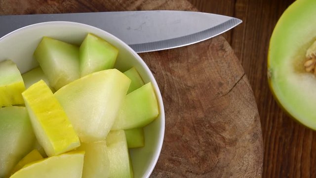 Portion of Honeydew Melon rotating on a wooden plate (not loopale; 4K)