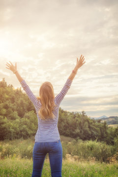 Woman enjoying in the nature with arms wide open.
