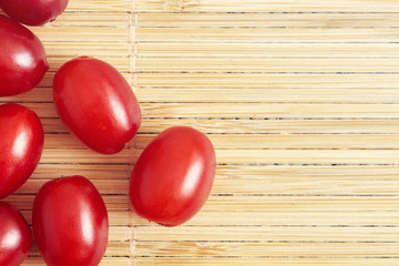 Fresh cornel berries (Cornus mas or Cornelian cherry) on wooden background. Top view with copy space