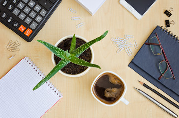 Top view office desk with notepads, phone, paper for notes, calc
