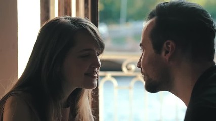 Gentle touch lovers noses. Man and woman in love on background open window