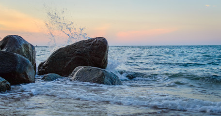 Wave splash in the sea against stone