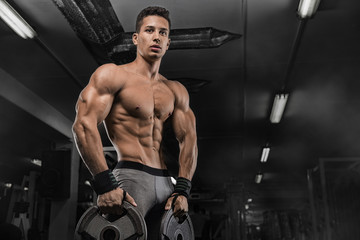 Fototapeta na wymiar Man Lifting Heavy Weights In The Gym. Athletic sport lifestyle