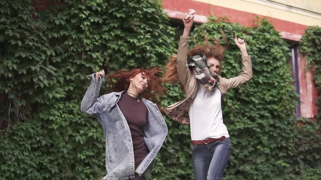 unbridled joy of two redheaded girlfriends. girls fooling around, having fun, laughing and jumping. girlfriends having fun together. slow motion