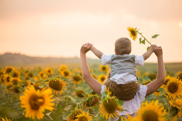 Mother with baby son in sunflower field