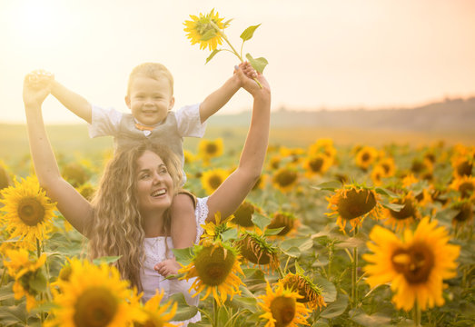 Mother with baby son in sunflower field