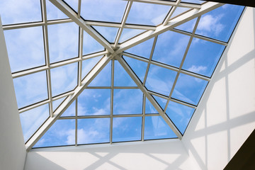 Ceilling. Blue sky and glass windows.