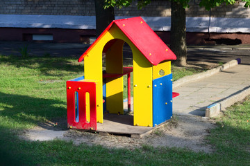 Colorful chilgren playground. Public park near houses  with grass and trees.