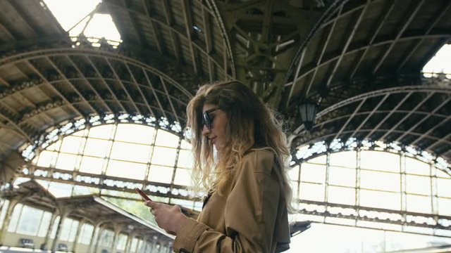 Woman With A Cell Phone On The Platform
