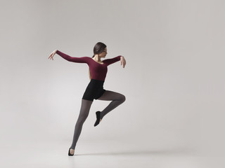 young woman dancer in maroon swimsuit posing