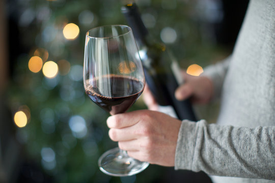 human hand holding wine glass. red wine, alcohol, celebration, temptation.