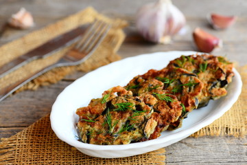 Easy fried eggplant fritters with dill and garlic on a white plate and on a vintage wooden table. Home quick eggplant fritters recipe. Vegetable food closeup
