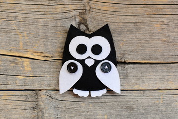 Stuffed felt owl ornament isolated on an old wooden background with empty copy space. DIY sewing crafts from felt. Owl crafts concept for children. Closeup