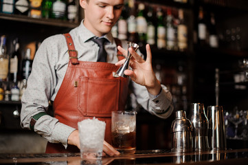 barman pouring cocktail in a glass