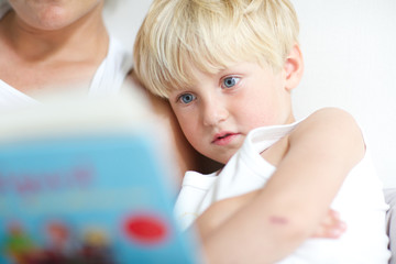 mother with son reading bedtime story. child, parent, bedroom, staring.