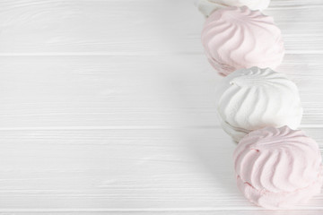 White and pink marshmallows on a white wooden table. Beautiful light background. Food