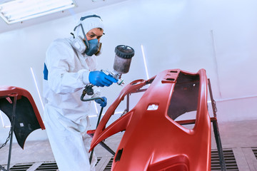 Painting the car's bumper red on the service.