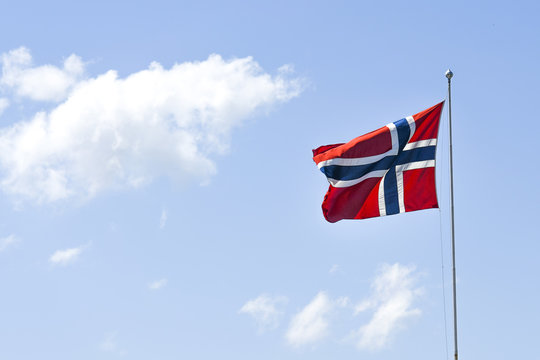 Flag of Norway, waving in the wind on a blue sky on a sunny day.