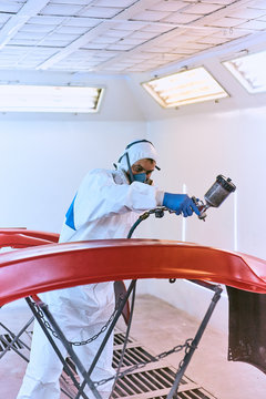 Painting bumpers machine red in the paint shop.