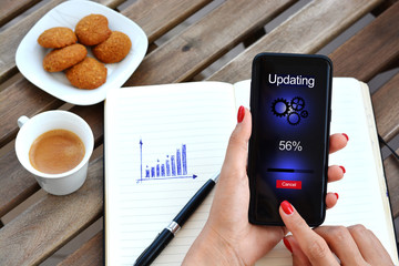 Smartphone software update concept or system operating upgrade with business woman updating mobile phone at work 