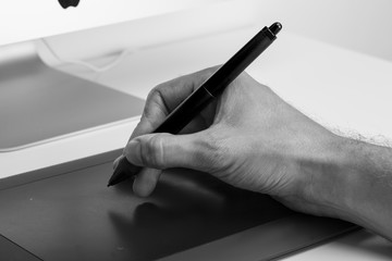 Close up photo of a man's hand holding a digital pen