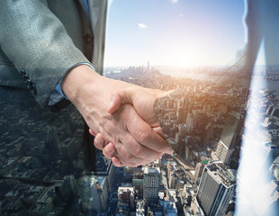 Business people shaking their hands in front of a big city