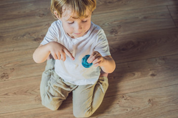 Young boy play with fidget spinner stress relieving toy