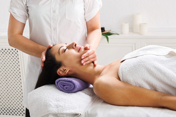 Fototapeta na wymiar Woman beautician doctor make head massage in spa wellness center