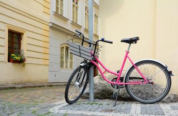 Pink bicycle in Prague. Bikes available for rental, parked in the city center.