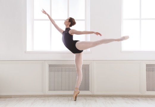 Fototapeta Beautiful ballerina stands in ballet arabesque