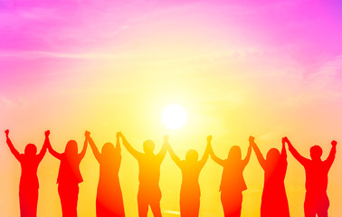 Fototapeta premium Silhouette a group of business people holding hand together, a sign of business successful, cooperation, teamwork concept