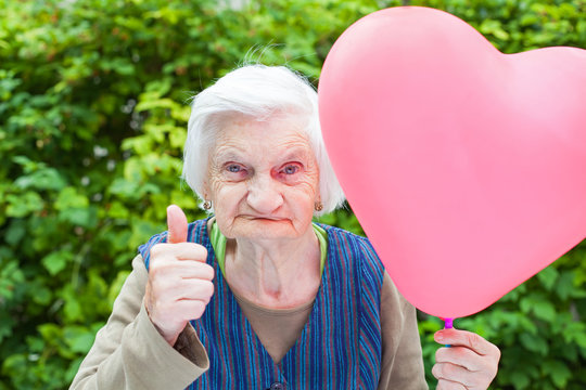 Elderly lady holding a heart shaped balloon