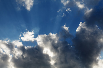 Clouds with rays of sun on a background of blue sky