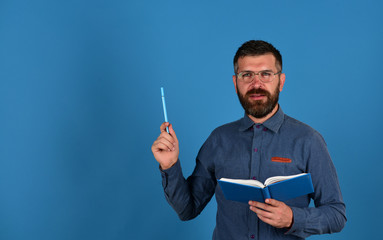 Man with beard, book and pen. Professor with concentrated face
