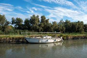 Fototapeta na wymiar Old white boat moored to shore