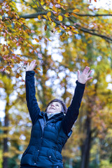 Woman stretches herself and hops with joy in the autumn wood