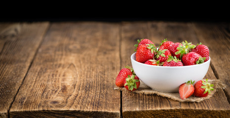 Strawberries on wooden background; selective focus