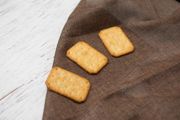 Homemade thin crispy cheesy crackers with sesame seeds in rustic wooden,Dry thin crackers