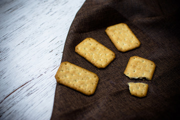 Homemade thin crispy cheesy crackers with sesame seeds in rustic wooden,Dry thin crackers
