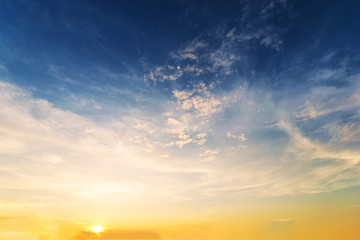 Fototapeta premium Sky background at sunset,Sky blue and orange light of the sun through the clouds in the sky
