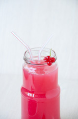 On beige background, a red currant drink