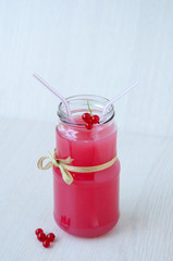On beige background, a red currant drink