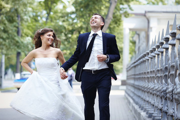 Happy bride and groom running laugh laughing on wedding day