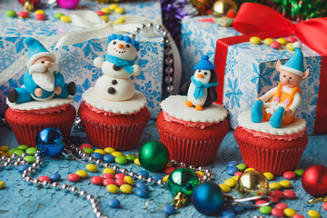 Fototapeta na wymiar Christmas cupcakes with colored decorations made from confectionery mastic