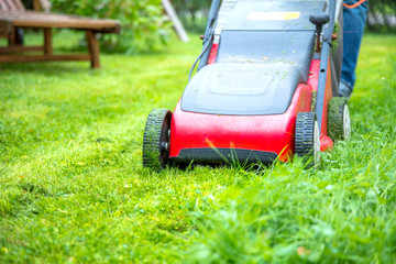 Mann Mäht rasen im eigenem Garten 