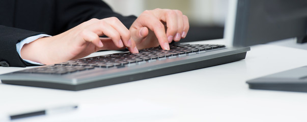 junge frau schreibt auf einer computertastatur