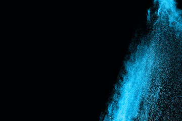 Abstract blue powder splatted on white background. Freeze motion of blue powder exploding on...